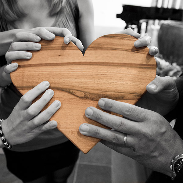 hands holding wooden heart